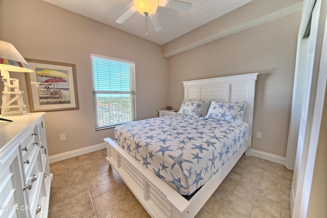 tiled bedroom featuring ceiling fan