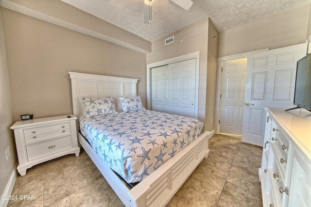 bedroom with ceiling fan, a closet, and a textured ceiling