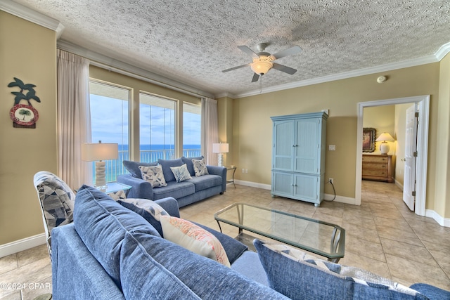 living room with a water view, a textured ceiling, and light tile patterned floors