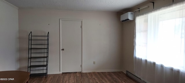 empty room with a wall mounted AC, a baseboard heating unit, dark wood-type flooring, and a wealth of natural light