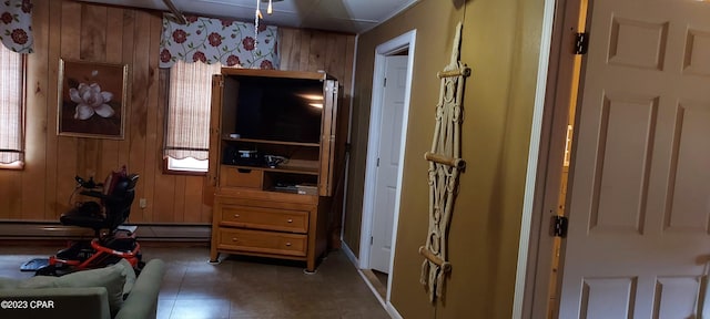 interior space featuring wooden walls and a baseboard heating unit