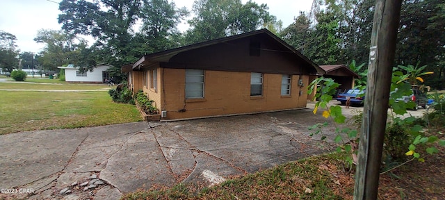 view of side of home featuring a yard and a patio