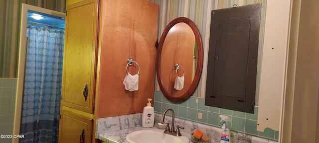 bathroom featuring tile walls, tasteful backsplash, and sink