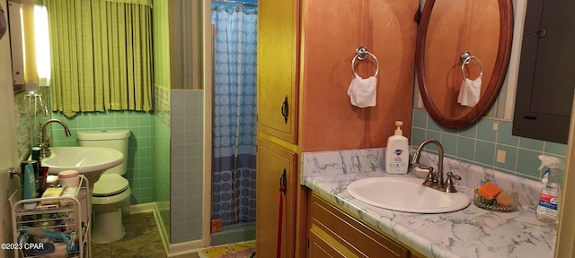 bathroom with curtained shower, backsplash, tile walls, toilet, and oversized vanity