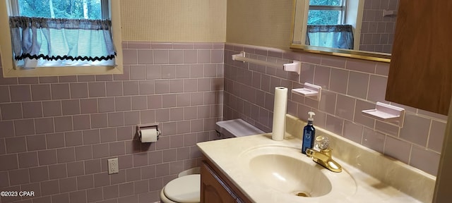 bathroom with tile walls, tasteful backsplash, toilet, and a wealth of natural light