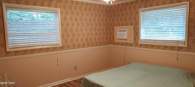 unfurnished bedroom with an AC wall unit and wood-type flooring