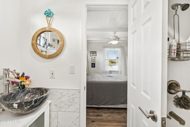 bathroom featuring hardwood / wood-style floors, vanity, ceiling fan, and beamed ceiling