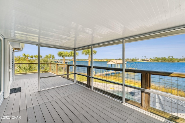 unfurnished sunroom featuring a water view