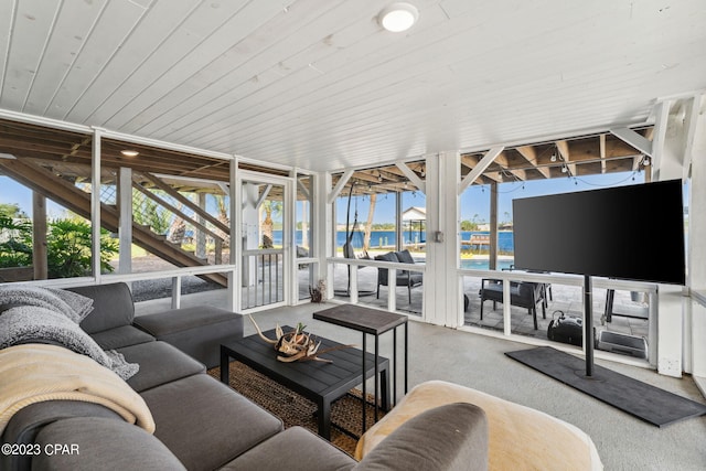 carpeted living room featuring a water view