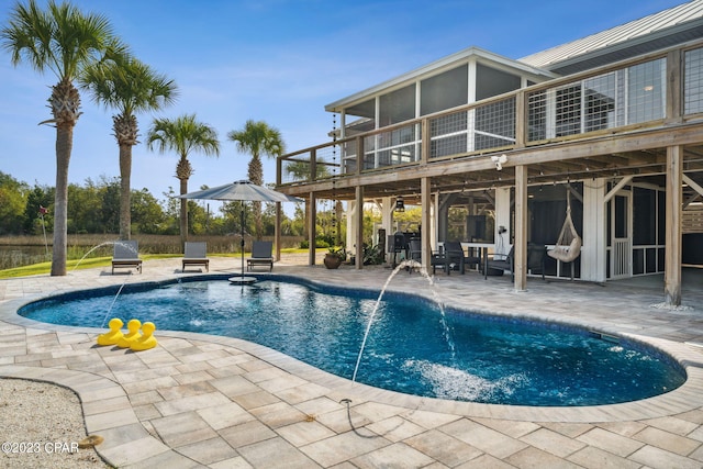 view of swimming pool with pool water feature and a patio