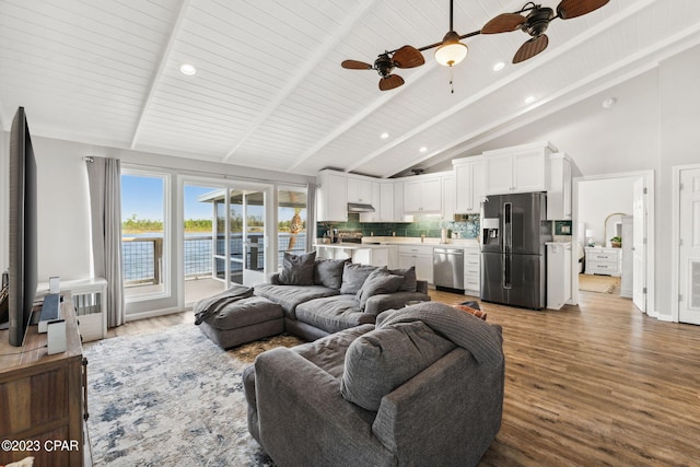 living room with light hardwood / wood-style floors, ceiling fan, high vaulted ceiling, and beamed ceiling