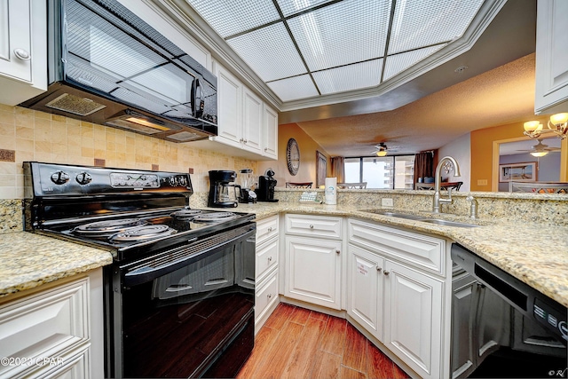 kitchen featuring sink, white cabinets, light wood-type flooring, and black appliances