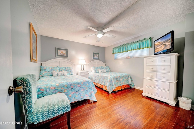 bedroom with hardwood / wood-style flooring, ceiling fan, and a textured ceiling