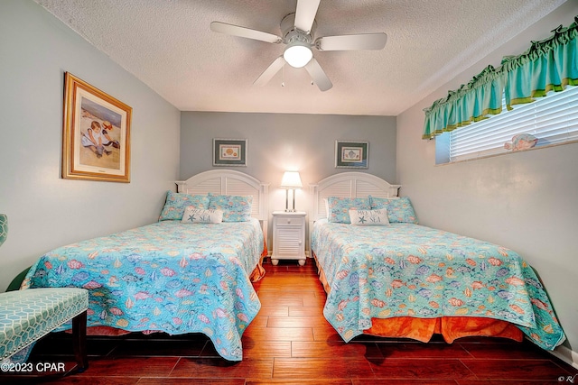 bedroom with ceiling fan, wood-type flooring, and a textured ceiling