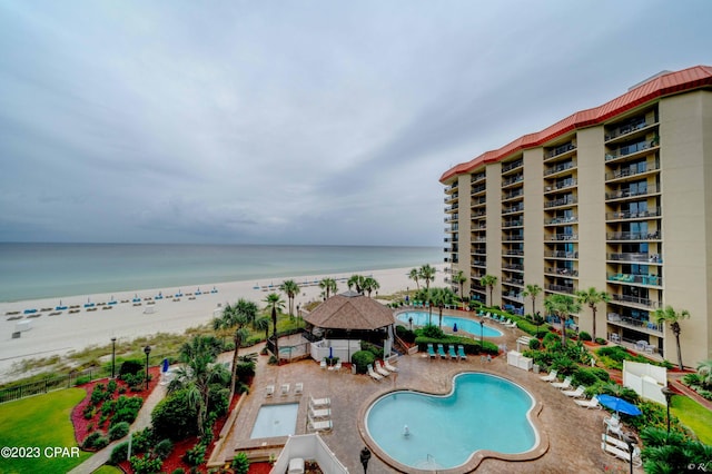 view of swimming pool with a gazebo, a patio area, a beach view, and a water view