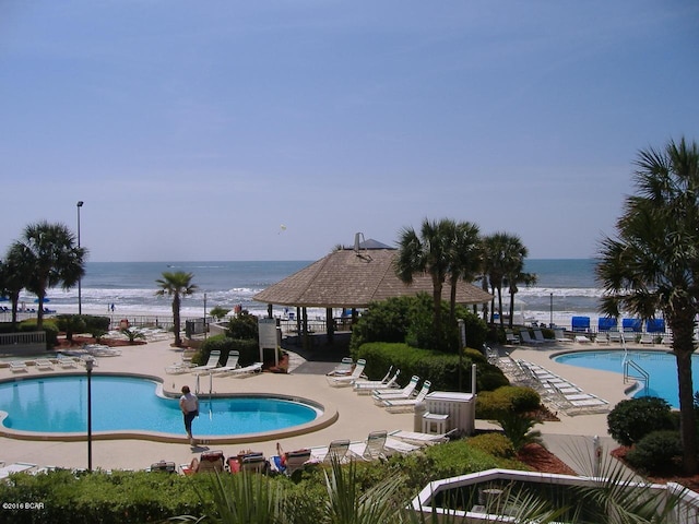 view of swimming pool with a patio and a water view