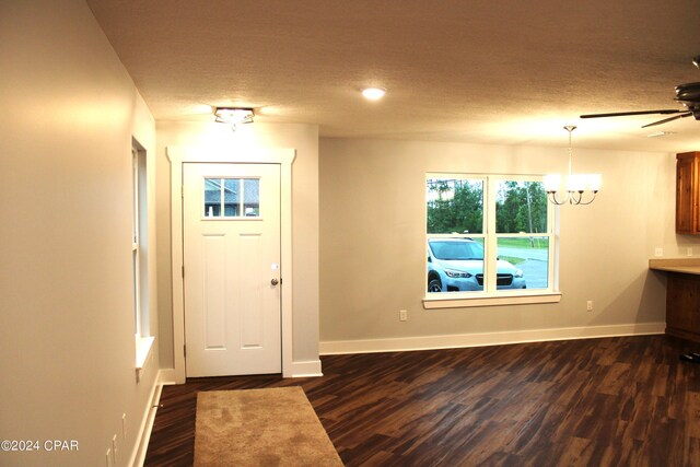 entryway featuring a textured ceiling, ceiling fan with notable chandelier, and dark hardwood / wood-style floors