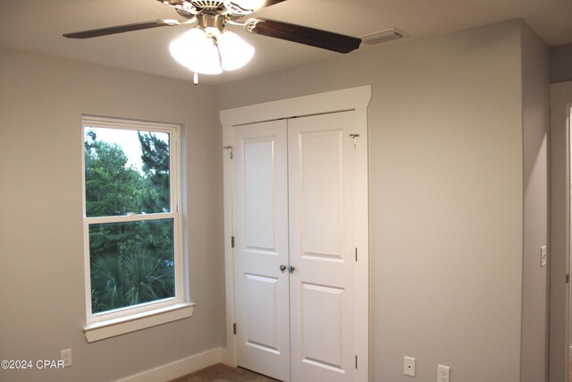 unfurnished bedroom featuring ceiling fan and a closet