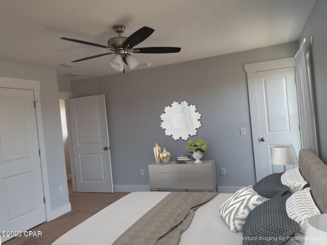 carpeted bedroom featuring ceiling fan and a textured ceiling