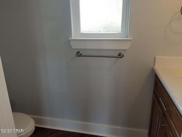 bathroom with toilet, vanity, and hardwood / wood-style flooring