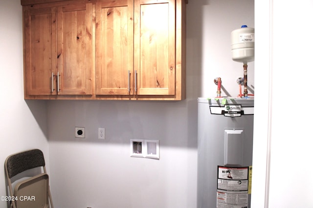 clothes washing area with cabinets, washer hookup, electric water heater, and electric dryer hookup