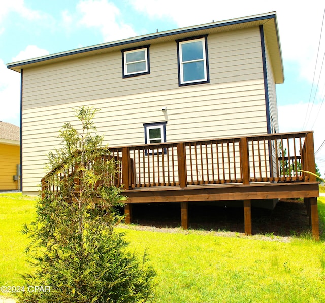 back of property with a deck and a lawn