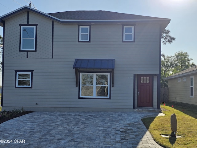 rear view of house featuring a yard