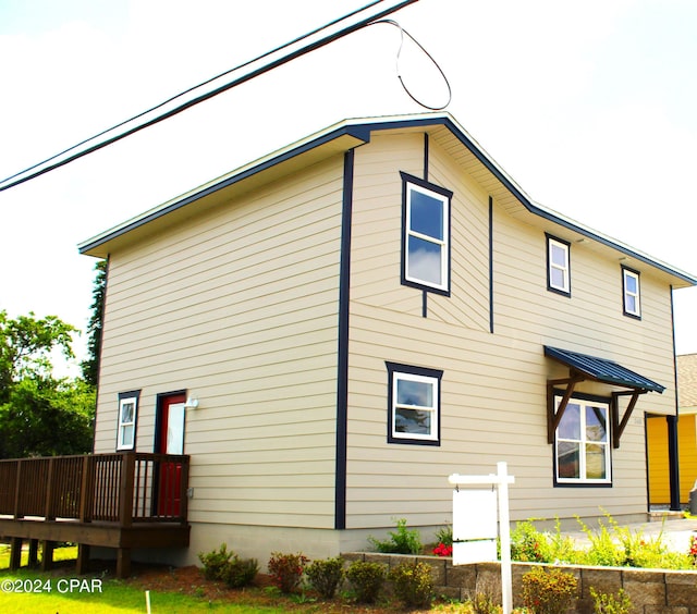 view of property exterior with a wooden deck