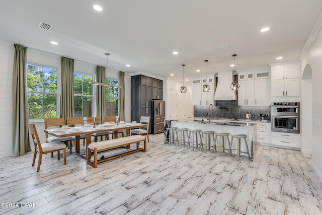 dining area featuring crown molding and light hardwood / wood-style flooring