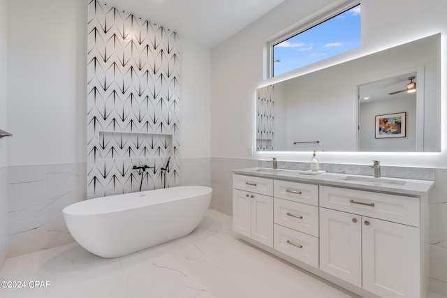 bathroom with tile walls, ceiling fan, double vanity, and tile flooring