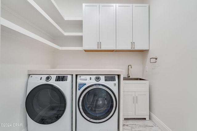 laundry area featuring cabinets, sink, and separate washer and dryer