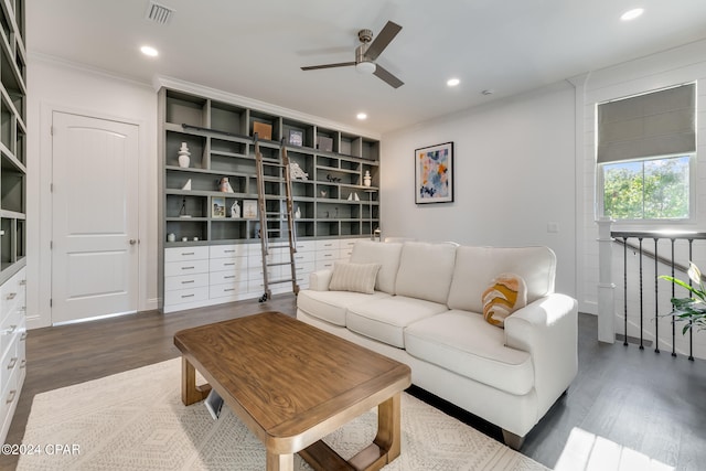 living room with dark hardwood / wood-style floors, ceiling fan, and ornamental molding