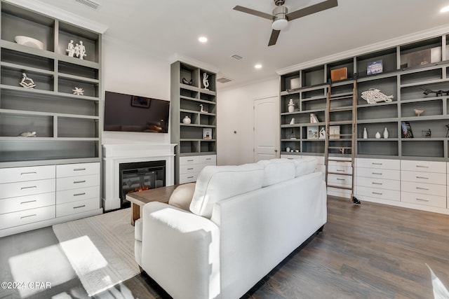 living room featuring dark hardwood / wood-style floors, ceiling fan, and crown molding