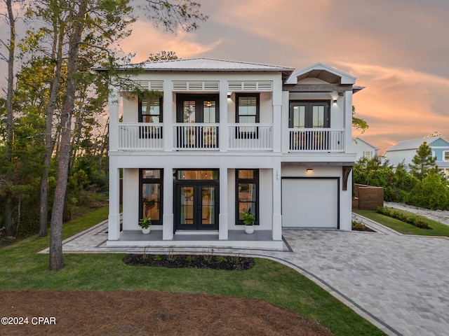 view of front facade with french doors, a balcony, and a garage