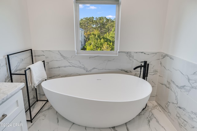 bathroom with tile walls, a tub, vanity, and tile flooring