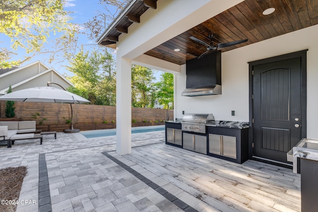 view of patio / terrace with an outdoor kitchen, ceiling fan, grilling area, and a fenced in pool