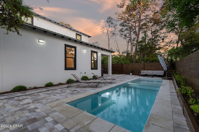 pool at dusk with a patio