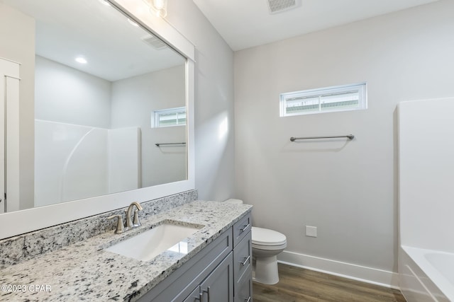 bathroom with hardwood / wood-style floors, plenty of natural light, toilet, and vanity