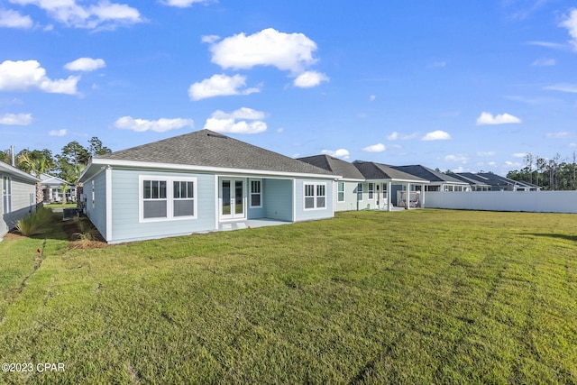 back of property with french doors and a yard