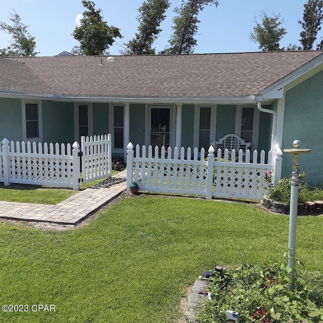 ranch-style house featuring covered porch and a front yard