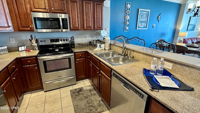 kitchen with light tile floors, light stone countertops, sink, and stainless steel appliances