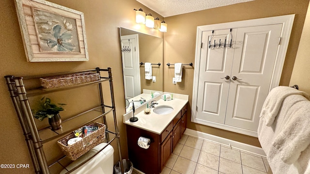 bathroom featuring tile flooring, large vanity, and a textured ceiling