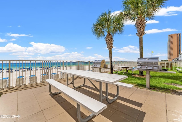 view of patio / terrace with a water view, grilling area, and a pool