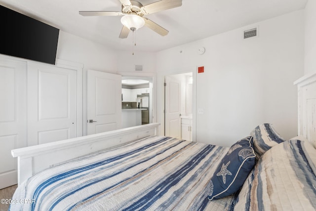 bedroom featuring a closet, stainless steel fridge, and ceiling fan