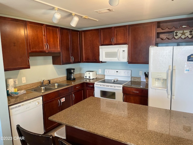 kitchen with rail lighting, white appliances, and sink