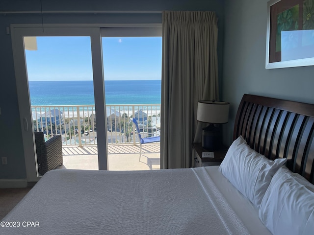 bedroom featuring access to outside, multiple windows, and a water view