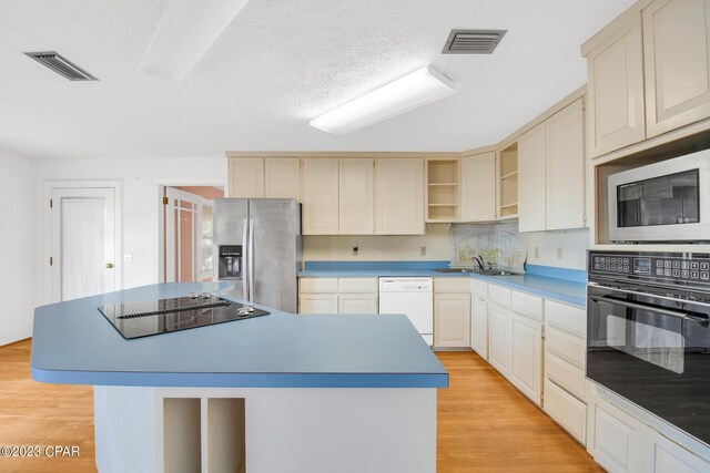 kitchen with a center island, sink, light hardwood / wood-style floors, and black appliances