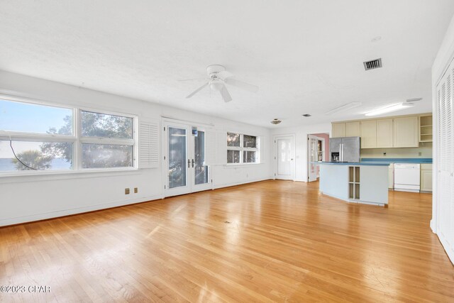 unfurnished living room featuring ceiling fan, light hardwood / wood-style flooring, and a wealth of natural light