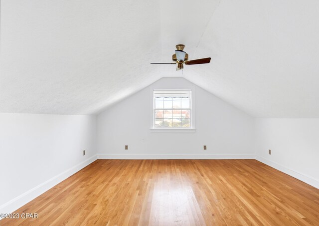 additional living space featuring lofted ceiling and light wood-type flooring