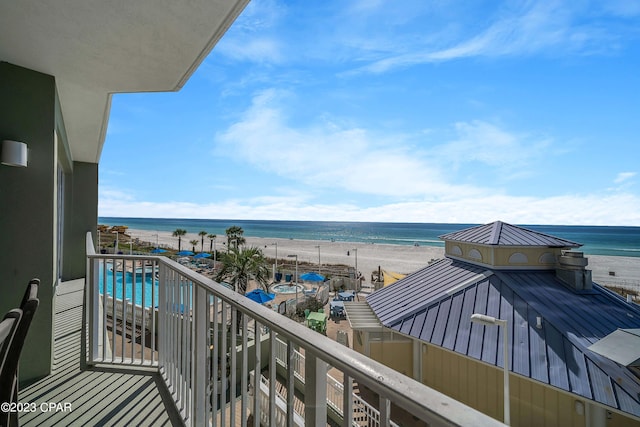 balcony featuring a view of the beach and a water view